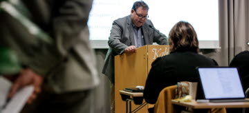 Peter Wretlund (S) håller ett anförande i talarstolen under ett möte med regionfullmäktige.