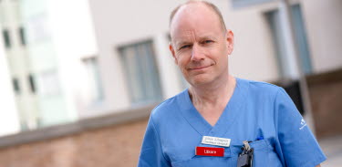 Johan Liliequist står i blåa sjukvårdskläder utanför Västerviks sjukhus.