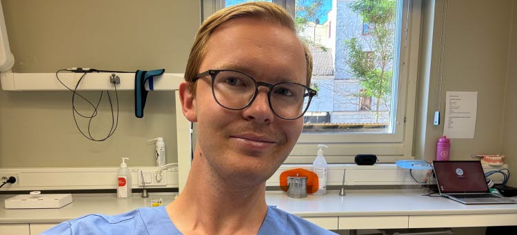 Manlig tandläkare i behandlingsrum.