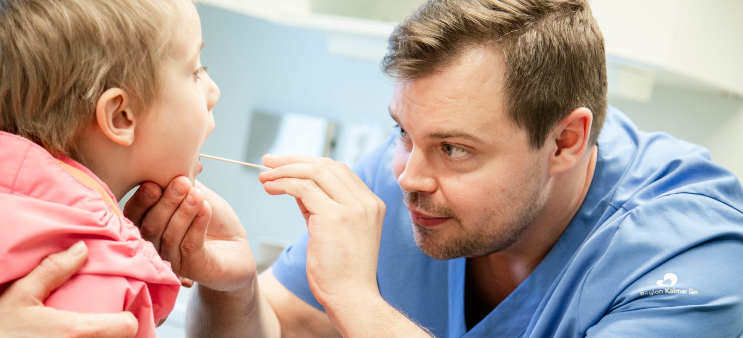 en läkare undersöker ett barn i halsen