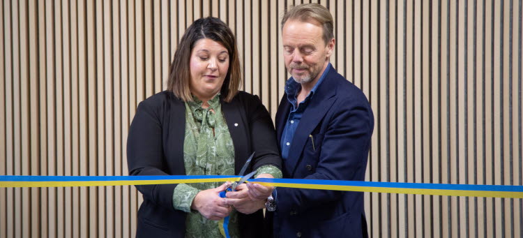 två personer klipper ett ceremoniellt band